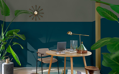 home office with two tone green wall with a round table