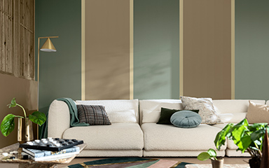 Living room with vertical  striped brown and green wall and cream sofa