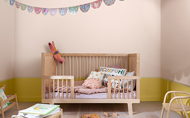 Child’s room with split wall in soft pink and straw yellow