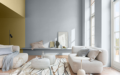 A vertical split wall in a living room using blue and straw yellow in a light and airy living room