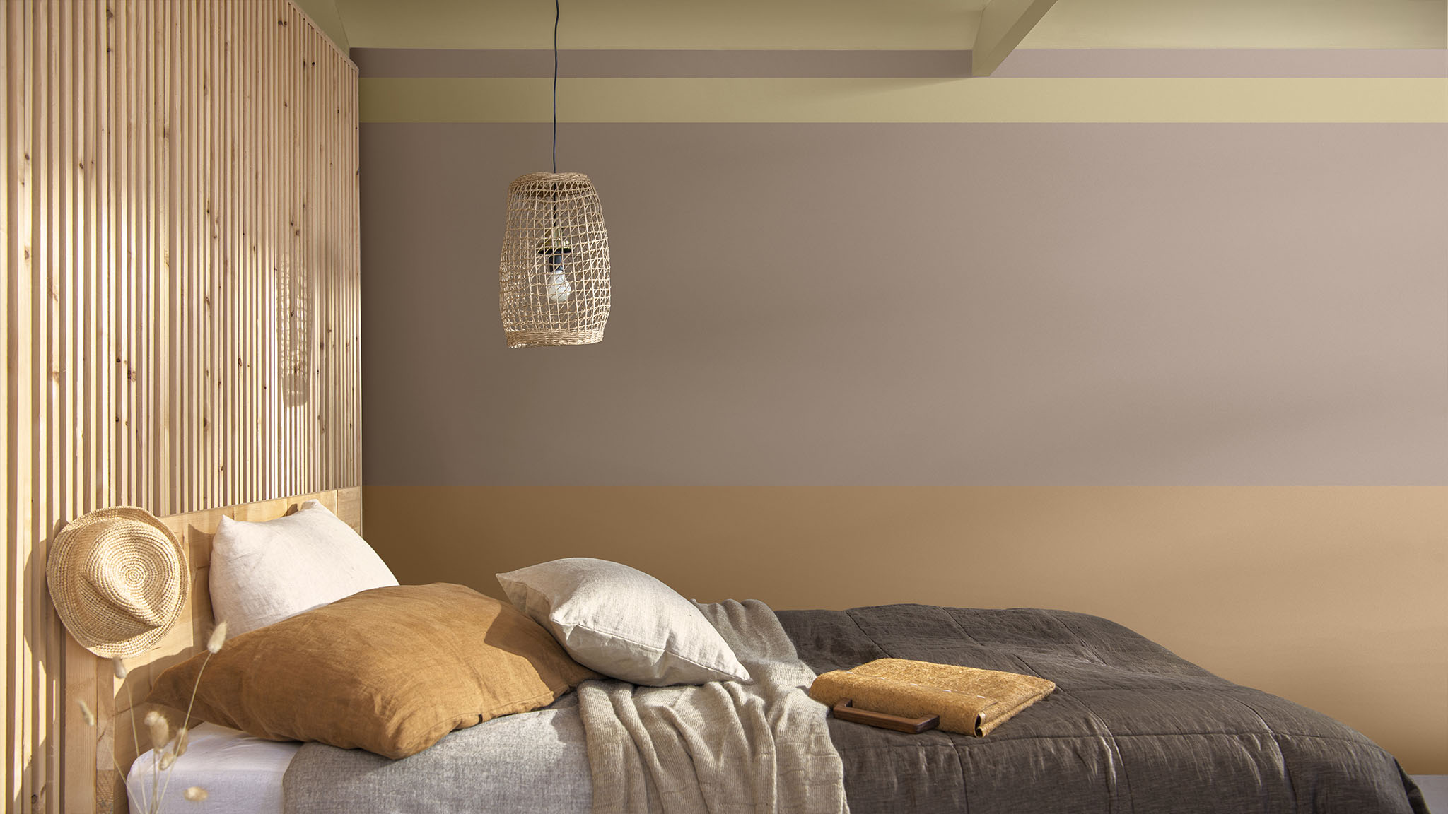 采用铁锈橘、淡粉色和野麦黄进行墙面分区的卧室