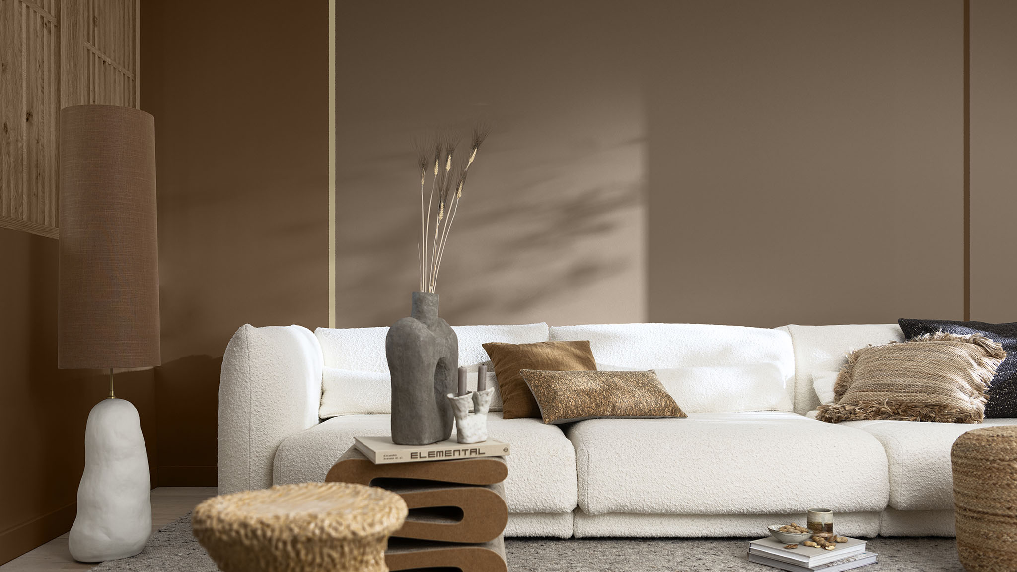 以两种不同色调棕色进行纵向分色打造背景墙的客厅，搭配奶油白沙发